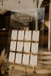 Papeterie de mariage avec invitations et menus élégants sur une table en bois.