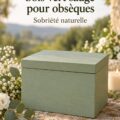 Urne funéraire en bois vert sauge exposée sur une table décorée avec des fleurs